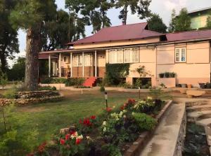 西隆Mid Hill Cottage Guest Suites Nongrim的门前有鲜花的房子