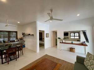 a living room and kitchen with a ceiling fan at Orchid Villa in Koh Tao