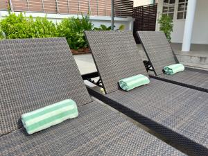 three chairs with green and white cushions sitting on a patio at Orchid Villa in Koh Tao