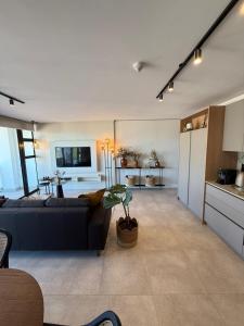 a living room with a couch and a kitchen at Views on August - Penthouse Unit 9 in Cape Town