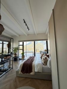 a bedroom with a large bed with a large window at Views on August - Penthouse Unit 9 in Cape Town