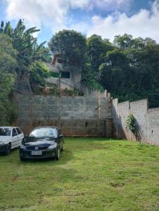 a black car parked next to a brick wall at Chácara Amorim in Mairiporã +5 photos