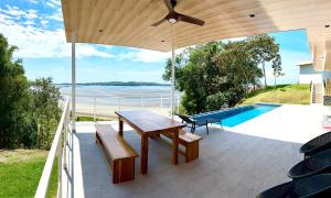 a patio with a wooden table and bench and a pool at Villa Sea La Vie in Boca Chica