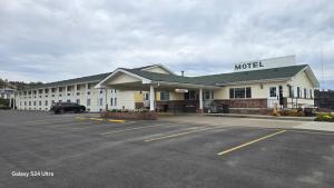 a motel with a car parked in a parking lot at Rails Inn in Forsyth