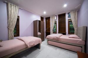 zwei Betten in einem Zimmer mit zwei Fenstern in der Unterkunft Villa Le Misk in Batureo 1