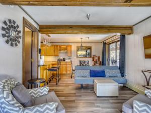 un salon avec un canapé bleu et une cuisine dans l'établissement Thunderhead Lodge #301 - Meredith Lodging, à Government Camp