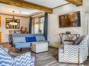 un salon avec un canapé bleu et deux chaises dans l'établissement Thunderhead Lodge #301 - Meredith Lodging, à Government Camp