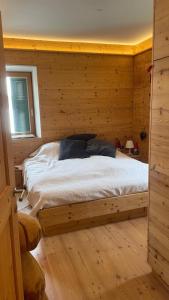 une chambre avec un lit dans une cabane en rondins dans l'établissement Olimpic games Cortina, à San Candido