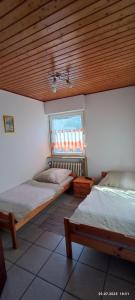 una camera da letto con due letti e soffitto in legno di Albferienhaus Schaette a Giengen an der Brenz