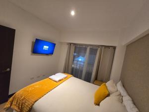 a bedroom with a bed with a tv on the wall at Apartment in Xela Quetzaltengo Interplaza hogar calido in Quetzaltenango +46 photos