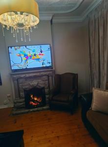 a living room with a fireplace and a tv at The Mining Station in Randfontein