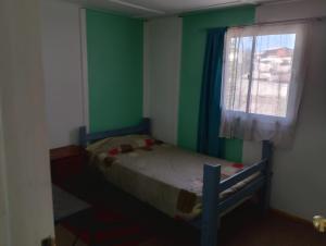 a small bedroom with a bed and a window at China 18, Coquimbo in Coquimbo