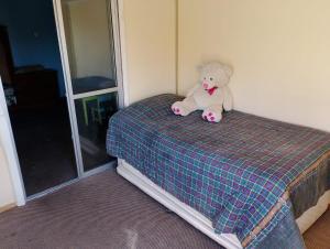a teddy bear sitting on top of a bed at China 18, Coquimbo in Coquimbo