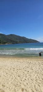 a sandy beach with a view of the ocean at casa da Cilene in Angra dos Reis +1 photo