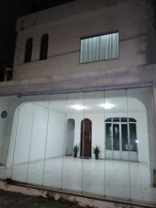 a white building with a glass facade with a door at Suite Umarizal cop30 in Belém