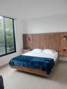 a bedroom with a large bed with a blue blanket at Apto 305 Exclusivo Turistico Moderno Acogedor Barrio Laureles nte Armenia Piscina Sauna Balcon Vigilancia Parqueadero Gratis Cerca Portal Quindio, Restaurantes in Armenia +35 photos