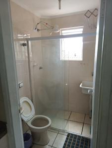 a bathroom with a shower and a toilet and a sink at Pousada Praia Grande Apartamento Familiar in Praia Grande
