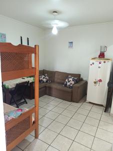 a living room with a couch and a refrigerator at Pousada Praia Grande Apartamento Familiar in Praia Grande