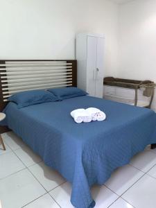 a blue bed with two towels on top of it at Apt aconchegante perto do shopping in Petrolina