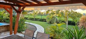 an outdoor patio with two chairs and a garden at La Promenade des Colibris in Saint-François