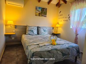 a bedroom with a bed with a stuffed animal on it at La Promenade des Colibris in Saint-François +12 photos