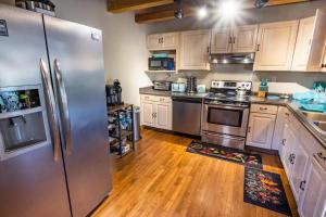 eine Küche mit Küchengeräten aus Edelstahl und Holzböden in der Unterkunft Ascension Cabin - hot tub, fire pit, babbling brook in Mount Nebo