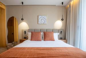 ein Schlafzimmer mit einem großen Bett mit orangefarbenen Kissen in der Unterkunft The Magic Place - Ocean Walk and Pool Access in Anfa-Supérieur