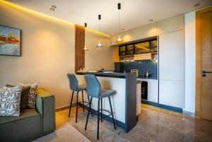 eine Küche mit einer Bar mit Hockern und einem Sofa in der Unterkunft The Magic Place - Ocean Walk and Pool Access in Anfa-Supérieur + 21 Fotos