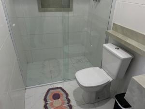 a white bathroom with a toilet and a shower at Casa Aconchegante em Biguaçu próximo às praias in Biguaçu +16 photos