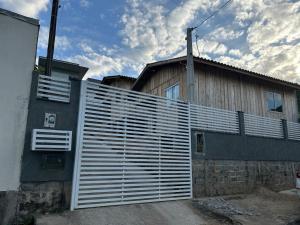 a fence in front of a house with a building at Casa Aconchegante em Biguaçu próximo às praias in Biguaçu
