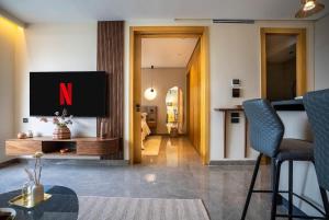 ein Wohnzimmer mit einem Fernseher mit dem Buchstaben N darauf in der Unterkunft The Iconic Spot - Pool and Sea View in Anfa-Supérieur