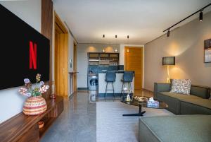 ein Wohnzimmer mit Couch und Tisch und eine Küche in der Unterkunft The Iconic Spot - Pool and Sea View in Anfa-Supérieur