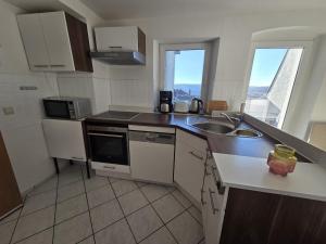 een kleine keuken met een spoelbak en een magnetron bij Helles Maisonette Apartment in Gera