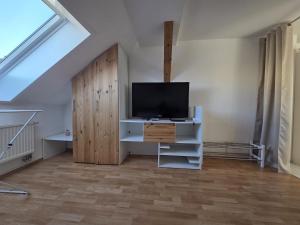 een woonkamer met een tv op een stand met een kast bij Helles Maisonette Apartment in Gera