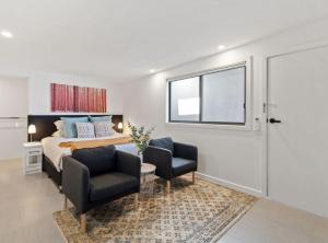 a bedroom with a bed and two chairs and a window at Cozy 1-Bed Studio Near Cafes and Shops in Carnegie