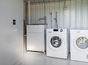 a laundry room with a washer and a washing machine at Cozy 1-Bed Studio Near Cafes and Shops in Carnegie