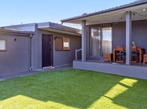 a house with a yard of green grass at Cozy 1-Bed Studio Near Cafes and Shops in Carnegie