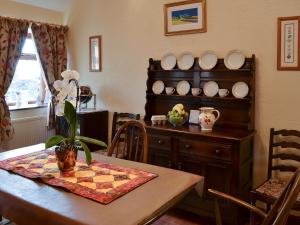 a dining room with a table and plates on a shelf at Swallows Nest-18094 in Cloughton