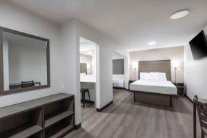 een hotelkamer met een bed en een spiegel bij Extended Stay America Suites - Columbia - Greystone in Columbia
