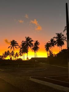 a sunset with palm trees in a parking lot at Casa de Carne de Vaca in Goiana +13 photos