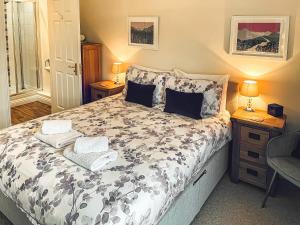 a bedroom with a bed with towels on it at 2 Greta Grove House in Keswick