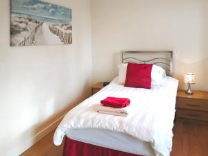 une chambre avec un lit blanc avec des oreillers rouges dans l'établissement Russet Cottage - E4678, à Lympsham