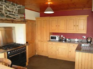 a kitchen with wooden cabinets and a black stove top oven at Overwater Lodge in Bassenthwaite Lake
