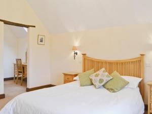 1 dormitorio con cama blanca y almohadas verdes en Stockham Lodge, en Colyton 11 fotos más