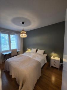 a bedroom with a large white bed and a chandelier at The Arctic Nordic Retreat in Rovaniemi