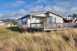 a house with a deck on the beach at Starboard Cottage in Waldport