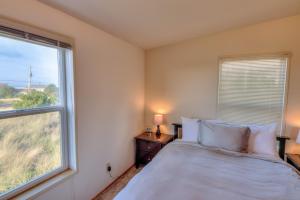a bedroom with a bed and a large window at Starboard Cottage in Waldport +36 photos