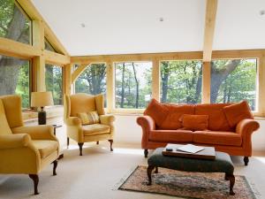 una sala de estar con un sofá y dos sillas en High Birch Close, en Penruddock