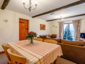 a living room with a table and a couch at Rafters Barn - E2064A in Runcton Holme