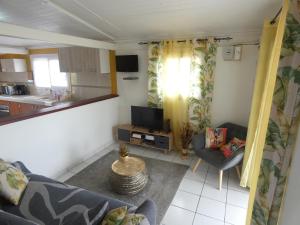 een kleine woonkamer met een bank en een keuken bij Gîte 2ch proche plages, Jardin privé, Port-Louis in Port-Louis